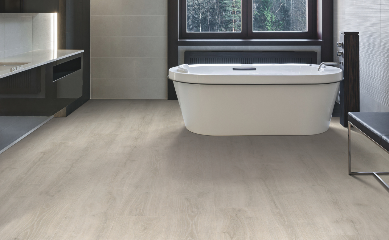 Light laminate flooring in a bathroom with a bathtub